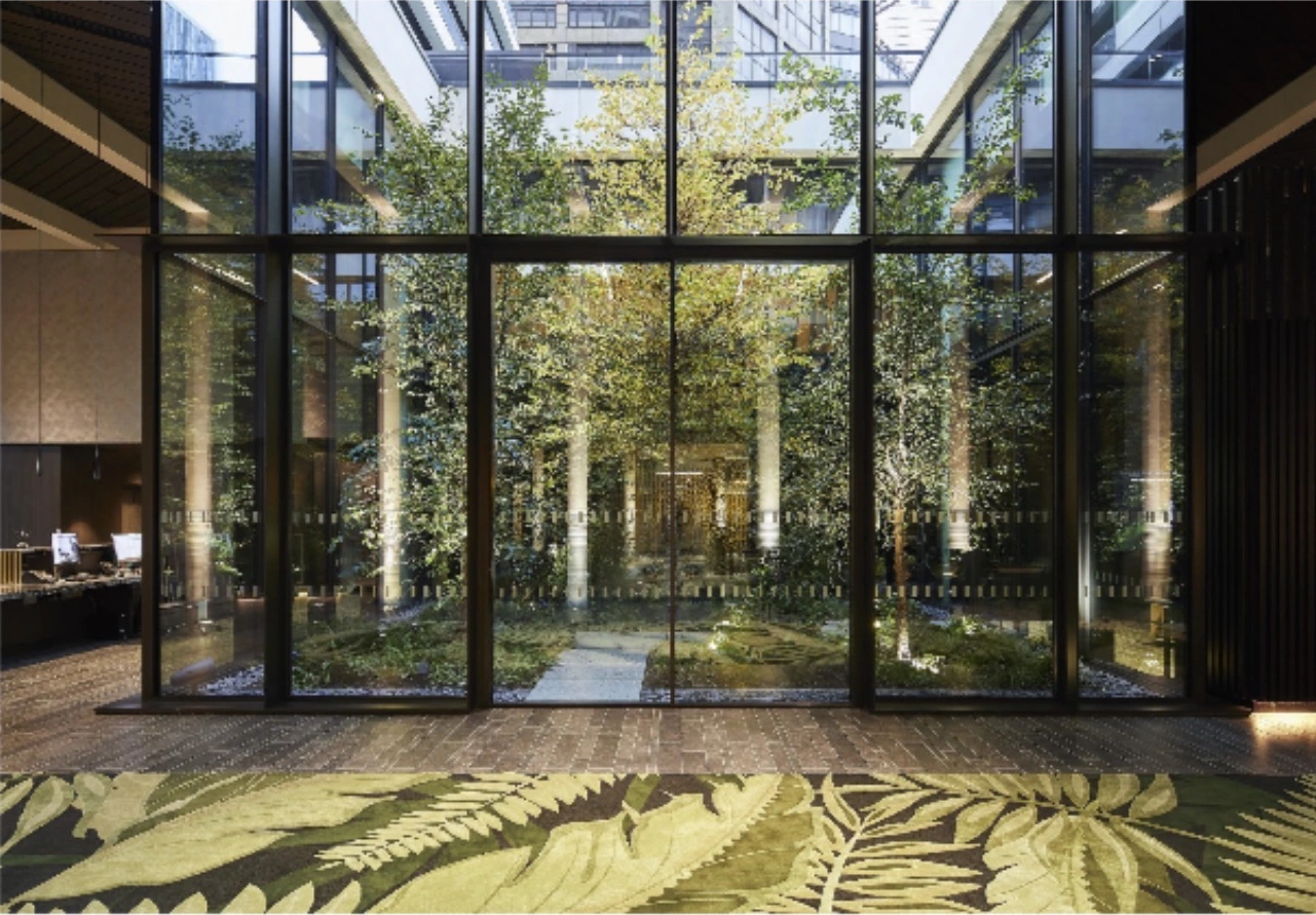 Green courtyard viewed from a shared interior